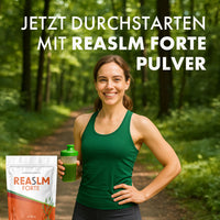 Thumbnail for Frau in Sportkleidung hält grünes Getränk im Wald neben REASLM Forte und großem Schriftzug oben
