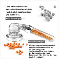 Thumbnail for Transparenter Duschkopf mit grauen und orangen Kugeln, daneben verstreute Kugeln auf weißem Hintergrund